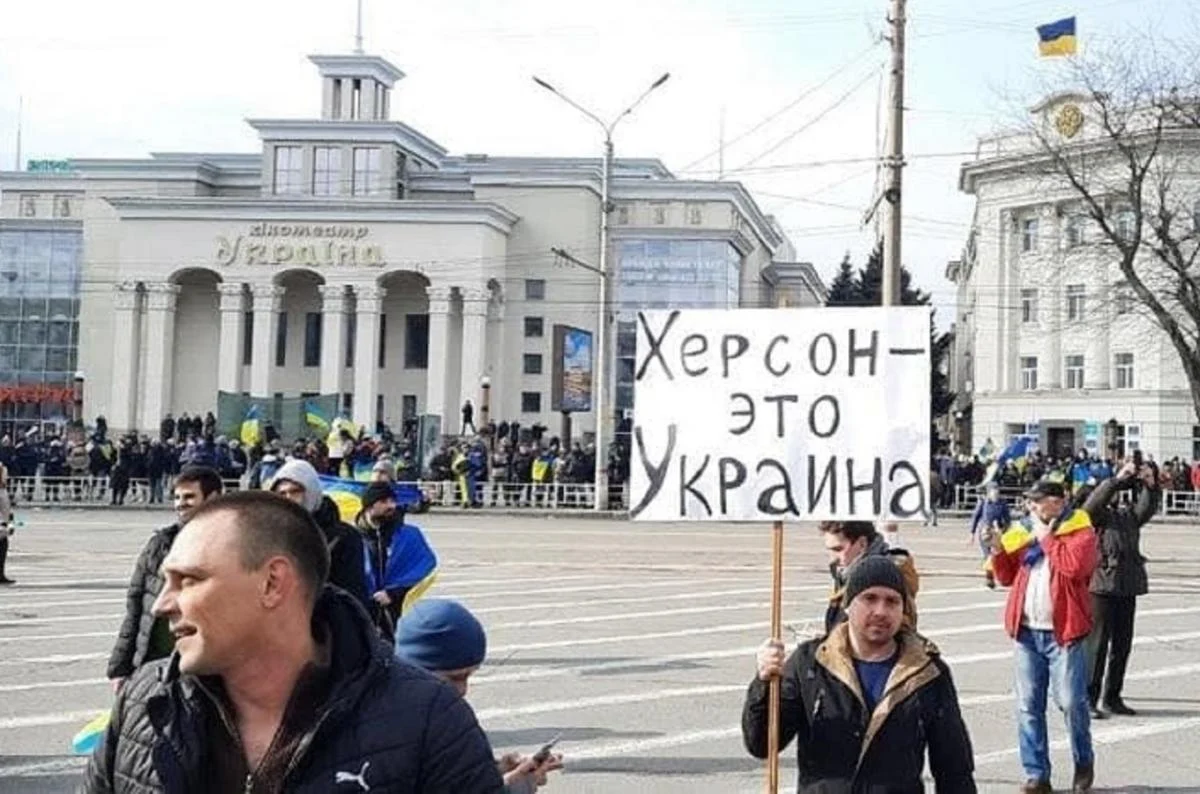 Březen 2022, jihoukrajinský Cherson, vzpoura proti tehdejším ruským okupantům. „Cherson je Ukrajina,“ stojí na tabuli. Rusky, ne ukrajinsky. Foto: UNIAN