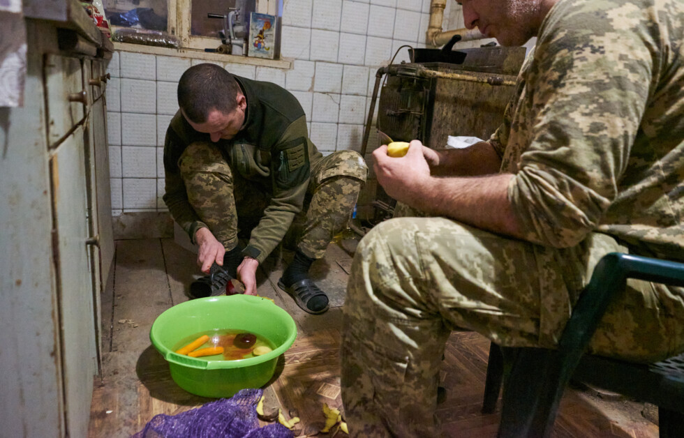 Soldiers from the 28th Intelligent Company of Knights of the Winter March peeling vegetables that will be used for borsch.